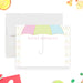 Personalized note card with a white front with a pastel pink, green, and blue umbrella, raindrop border, and personalized name. Shown with a white envelope.
