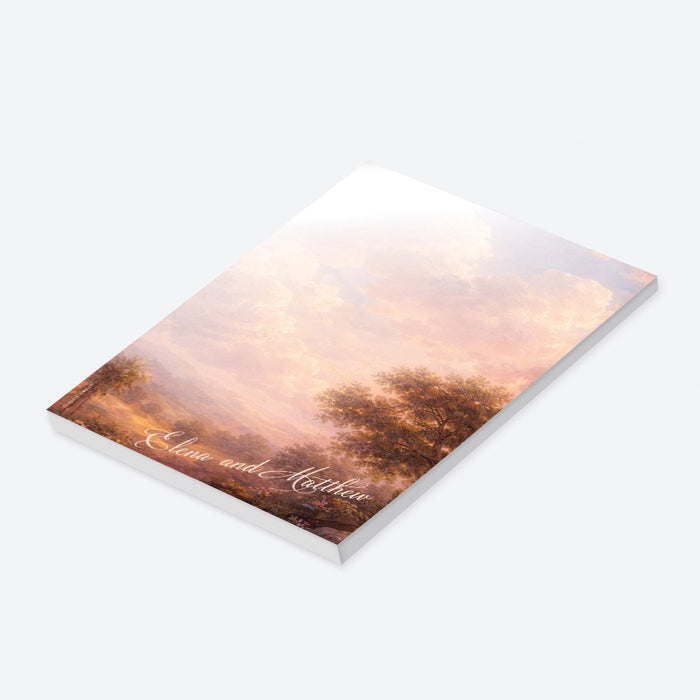 Personalized blank notepad with romantic vintage landscape painting, glowing pink clouds, countryside scenery and custom couple’s names-side