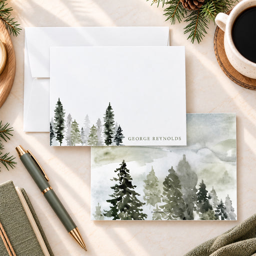 Personalized watercolor pine tree note card featuring muted green and gray evergreen trees along the bottom and a name in the corner.