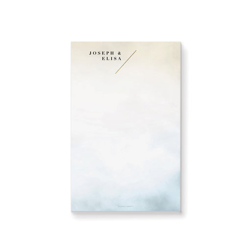 Custom notepad with a cream and blue watercolor wash background, personalized with names, perfect for elegant stationery or wedding party favors.