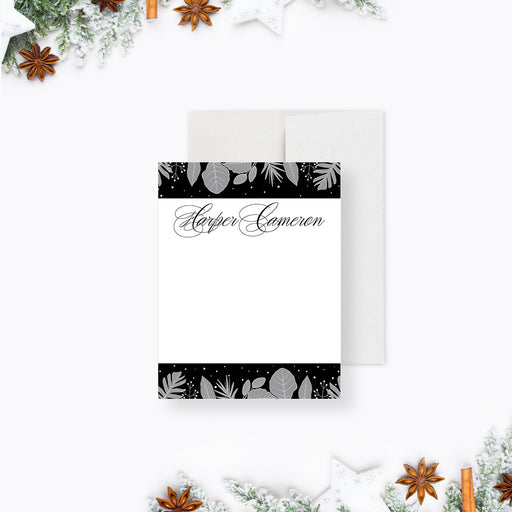 personalized winter botanical note card with custom name, gray foliage accents, black and white design, and blank writing space-front