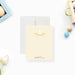 Personalized note card with a soft yellow front with a white bunny illustration and a name in script. Shown with a white envelope.