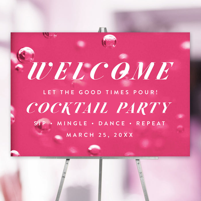 pink cocktail party welcome sign displayed on an easel with a bubbly drink design and bold white lettering