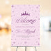 Bat mitzvah welcome sign in pink and purple with princess crown, star accents, and elegant script text for a party entrance display.