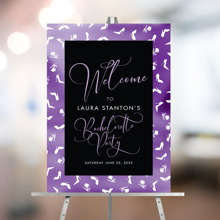 Purple bachelorette party welcome sign featuring a stiletto heels pattern, displayed on an easel.