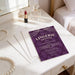 Purple tufted leather lingerie shower invitation featuring elegant pearls draped across the top and classic white typography