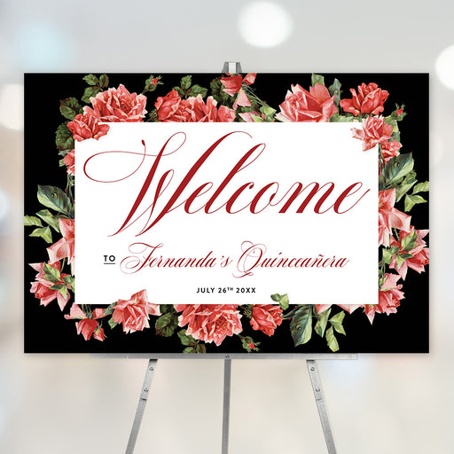 Personalized Quinceañera welcome sign with red script text and a red rose border, displayed on an easel.