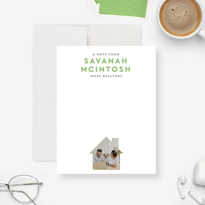 Personalized note card with a white front with green business wording and a house-shaped photo near the bottom. Shown with a white envelope.