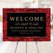 wedding anniversary welcome sign with red rose background and elegant black design displayed on easel