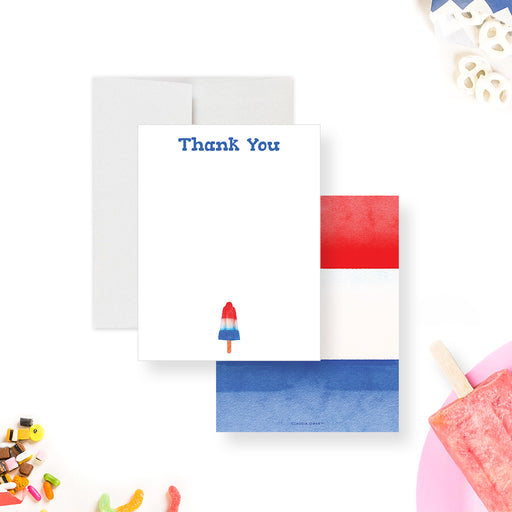 White thank you note card with a red white and blue rocket ice pop, beside a back with matching watercolor stripes.