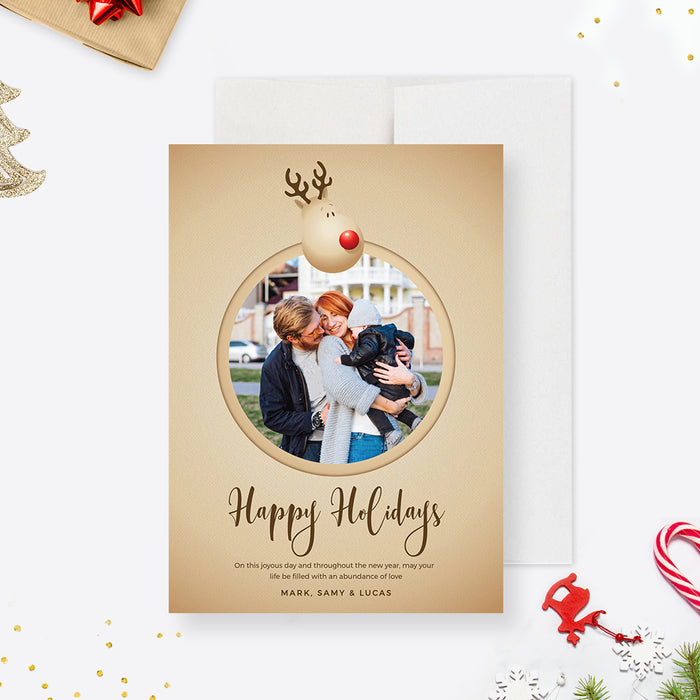 Reindeer Christmas photo card template with a round family photo frame, beige background and Happy Holidays script.