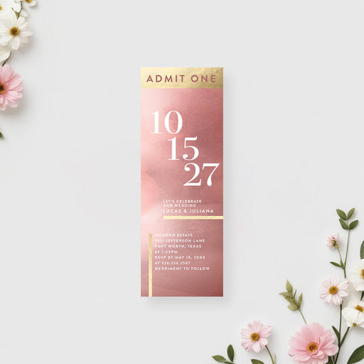 Ticket-style wedding invitation with a modern date layout and gold accents on a blush pink watercolor background