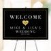 Romantic wedding welcome sign featuring elegant gold heart design on black background