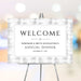 corporate annual dinner welcome sign with black and white formal layout, textured gray border, company name, and event date displayed on an easel