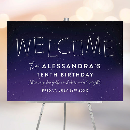 Starry night birthday welcome sign with constellation lettering on a navy-purple gradient background displayed on an easel