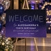 Starry night birthday welcome sign with constellation lettering on a navy-purple gradient background displayed on an easel