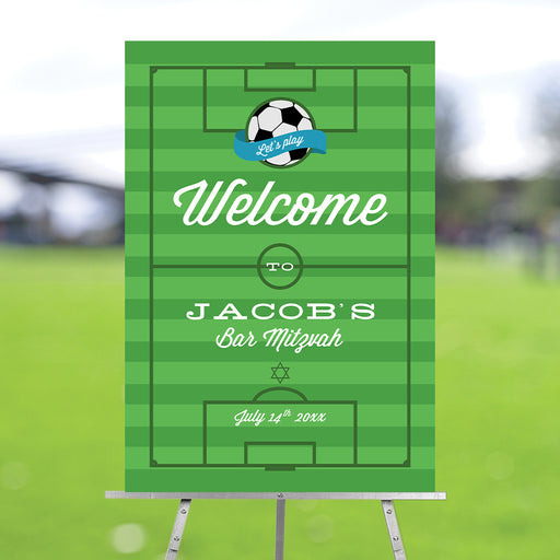 Personalized soccer-themed Bar Mitzvah welcome sign with a green field design, displayed on an easel for a sports-themed Jewish party
