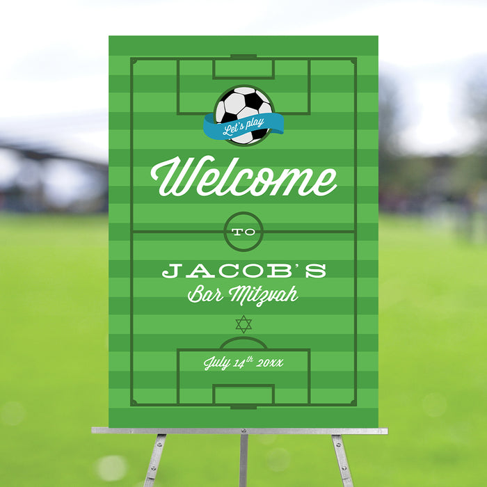 Personalized soccer-themed Bar Mitzvah welcome sign with a green field design, displayed on an easel for a sports-themed Jewish party