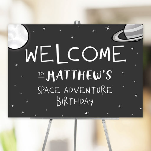 Space adventure birthday party welcome sign featuring a moon, planets, and twinkling stars