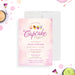 A blush pink invitation card with cupcake illustrations and details for a cupcake decorating party, displayed with cupcakes and party decorations in the background.