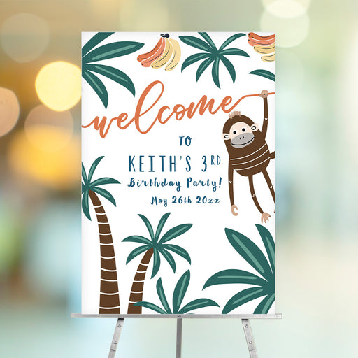 Jungle birthday welcome sign featuring a playful monkey, palm trees, and bananas for a tropical kids party entrance display.