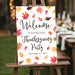 thanksgiving welcome sign with autumn leaves displayed on easel for fall party entrance