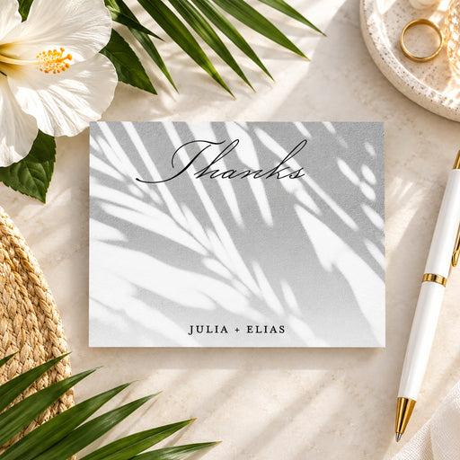 tropical wedding thank you card with soft palm shadow design and elegant script lettering for a beach or garden wedding-front