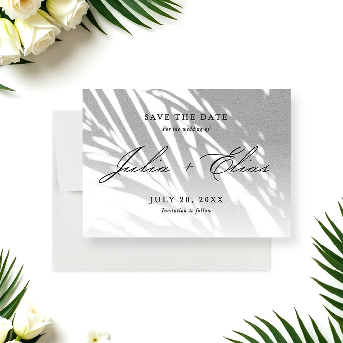 tropical wedding save the date card with soft palm shadow design and elegant script lettering for a beach or garden wedding-front