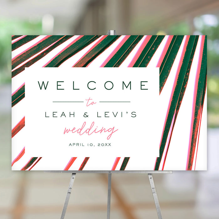 Tropical welcome sign featuring bright pink and green palm fronds, suitable for wedding ceremony entrances, reception displays, or event décor.