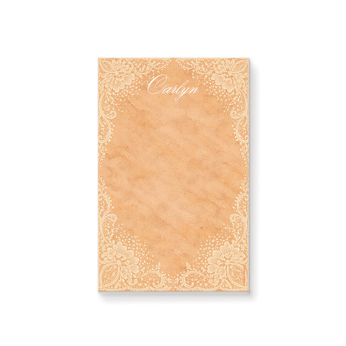 Personalized peach watercolor notepad with white floral lace borders and an elegant script name.