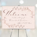 blush pink floral wedding welcome sign with vintage botanical line art and elegant script lettering displayed on an easel