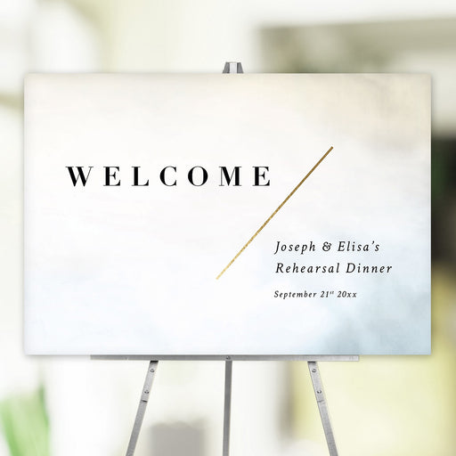 Minimalist welcome sign with bold black text and gold diagonal accent, personalized with names for rehearsal dinner, party signage, or event décor.
