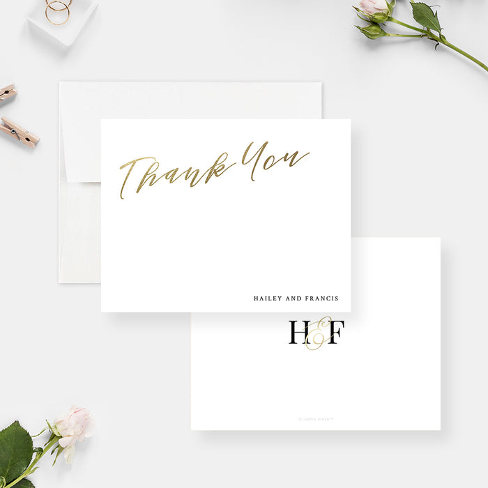 White wedding thank you cards with printed gold script lettering and personalized names on the front and a monogram on the reverse.