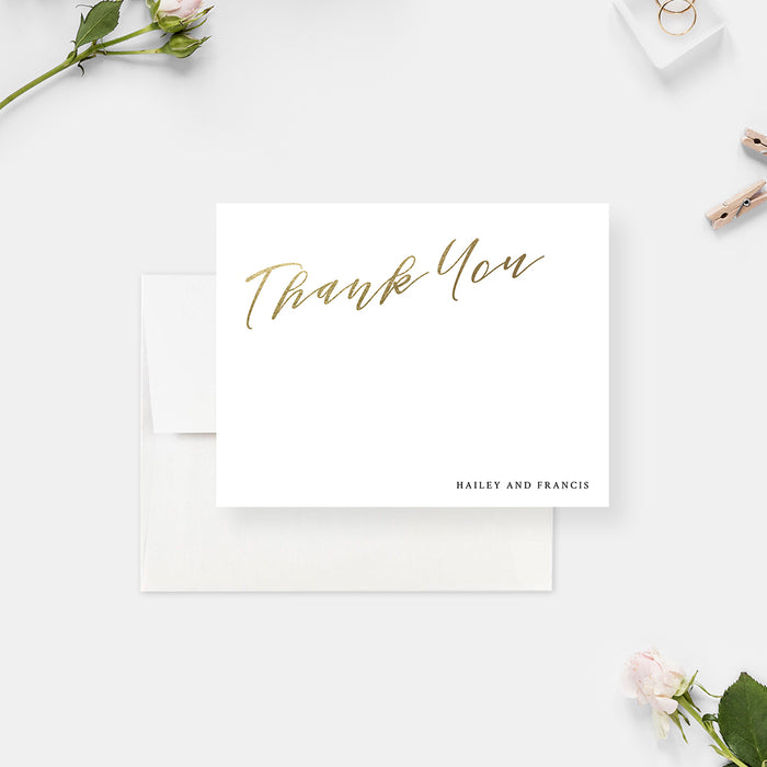 White wedding thank you cards with printed gold script lettering and personalized names on the front and a monogram on the reverse.