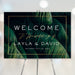 Tropical wedding welcome sign featuring greenery and palm leaves, elegant botanical poster used as event entrance signage