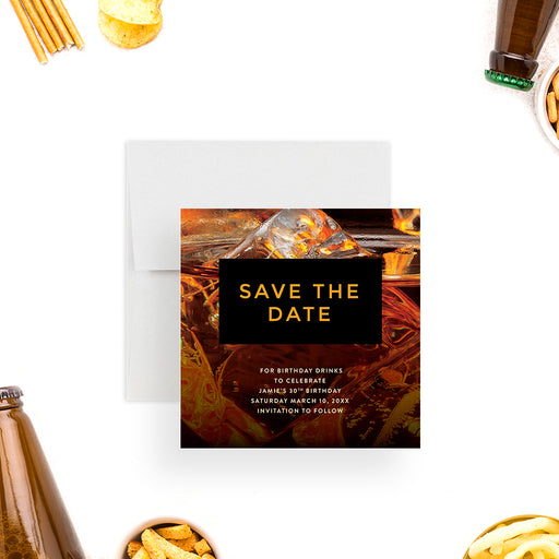 Whiskey-themed save the date card featuring bold gold lettering over an ice-filled cocktail background, perfect for adult birthdays or cocktail parties.-front