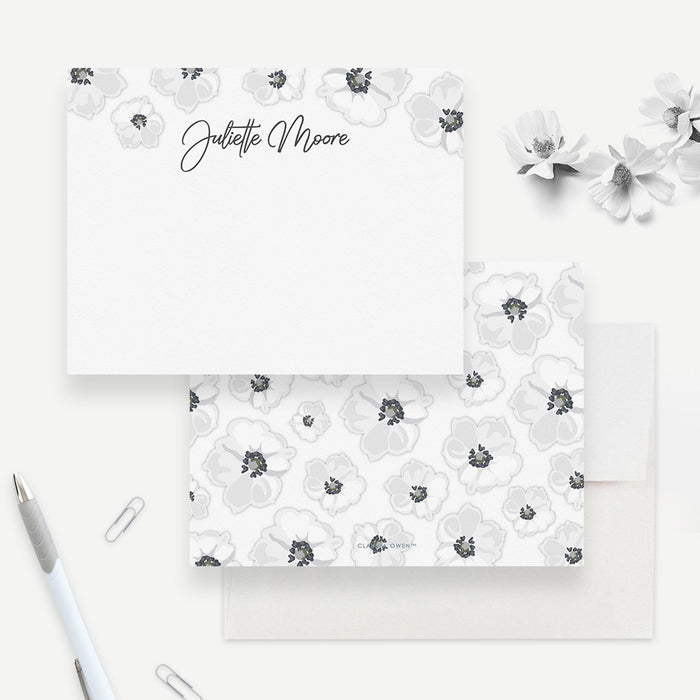 Personalized white floral note card front and back, with dark-centered white flowers, a script name and a matching flower pattern.