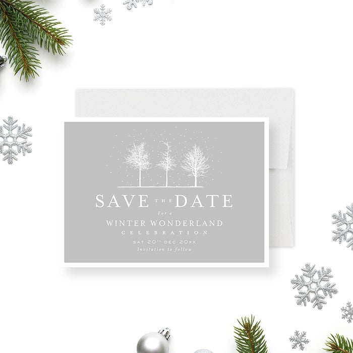Winter wonderland save the date card featuring snowy trees on a soft gray background with elegant minimalist typography.-front